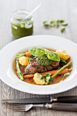 Beef fillet in broth with vegetables and pesto