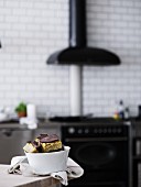 Slices of tray bake cake in a porcelain bowl on a table in a kitchen