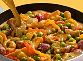 Chicken curry with peas, peppers, purple potatoes and cashew nuts