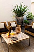 Wicker furniture around coffee table with planters to one side
