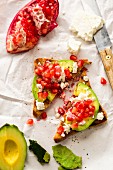 Wholemeal bread triangles with avocado, feta cheese and pomegranate seeds