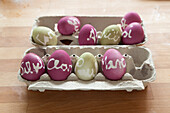 Dyed Easter eggs labelled with wax-resist names