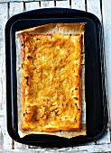 Puff pastry onion tart on a baking tray