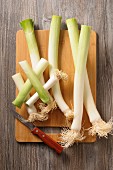 Fresh leek on a chopping board with a knife