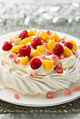 Mango and raspberry pavlova with pomegranate seeds