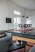 View from lounge area into dining area on platform below classic pendant lamps