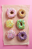 Doughnuts with glaze on a pink surface