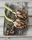Artichokes, beans and thyme on a wooden board