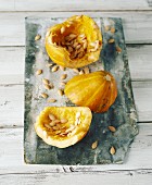 A sliced squash with seeds on a wooden board