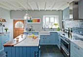 Landhausküche mit hellblauen Fronten, Mittelblock mit Arbeitsplatte aus Marmor und Walnussholz