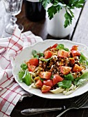 Pasta salad with minced meat, tomatoes and basil