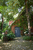 Climber-covered brick house in idyllic garden
