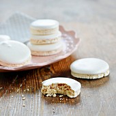 Macaroons on a plate and next to it, one with a bite taken out