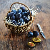 Plums in a rustic basket and next to it