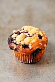 A yoghurt cupcake with blueberries and crumbles