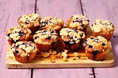 Yoghurt cupcakes with blueberries and crumbles on a wooden board