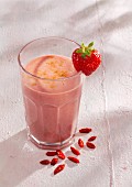 A strawberry and coconut smoothie with coconut milk and goji berries