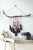 Wandschmuck mit Birkenast und aufgehängten DIY-Quasten aus Wollresten