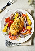 Chicken breast on a pepper medley with red onions (seen from above)