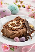 A slice of Easter chocolate log cake with chocolate cream and Easter eggs