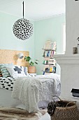 Graphic patterns and pastel turquoise wall in bedroom