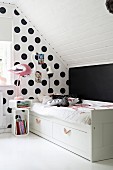 Bed against polka-dot wall in child's bedroom