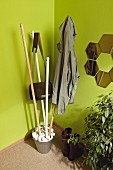 DIY coat rack made from broom handles, metal bucket and pebbles