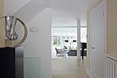 View from hallway into open-plan elegant interior with lounge area in front of terrace windows