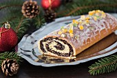 Traditional poppy seed roll cake with icing, dried fruits and nuts (Poland)