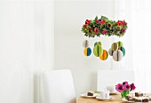 Colourful, hand-made Easter decorations hanging from flower wreath