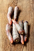 Purple carrots on a wooden surface