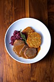 Beef Yankee pot roast with crispy potato fritters and braised red cabbage
