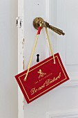 'Do not disturb' sign on traditional brass door handle