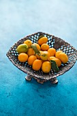 Kumquats mit Blättern in einer Metallschale