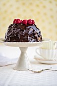 Gluten-free cake with avocado, cocoa and honey glaze and fresh raspberries