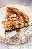 A slice of chocolate spread cheesecake with salted caramel and honey roasted peanuts