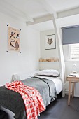 Single bed with red and white patterned blanket in corner below white wooden structure