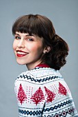 Dark-haired woman wearing knitted Christmas sweater