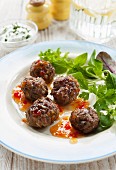 Meatballs with a sweet and spicy chilli sauce and a side salad