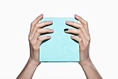 Woman's hands holding pale blue gift box