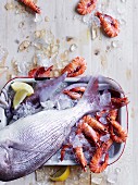 Fresh snapper and prawns on ice with lemons