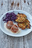 Pork medallions with a creamy mustard sauce served with a potato and apple cakes and red cabbage