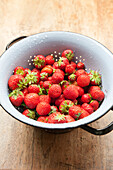 Freshly washed strawberries in a colander