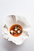 Vegetable and hibiscus tea broth with lobster medallions