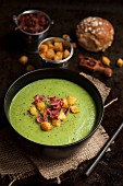 Spinach soup with celery, croutons and bacon strips