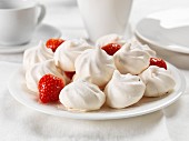 Strawberry meringues on a plate with fresh strawberries