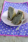 Two slices of poppyseed cake on a plate with a fork