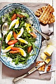 Rocket salad with egg and tomatoes served with toast and butter