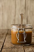 Dulce de leche in a flip-top jar with a spoon