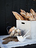 Fresh baguettes and a wooden crates and in a wire basket